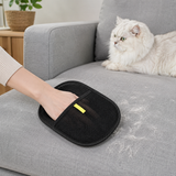 White cat sitting on a couch cleaned with the pet hair remover glove